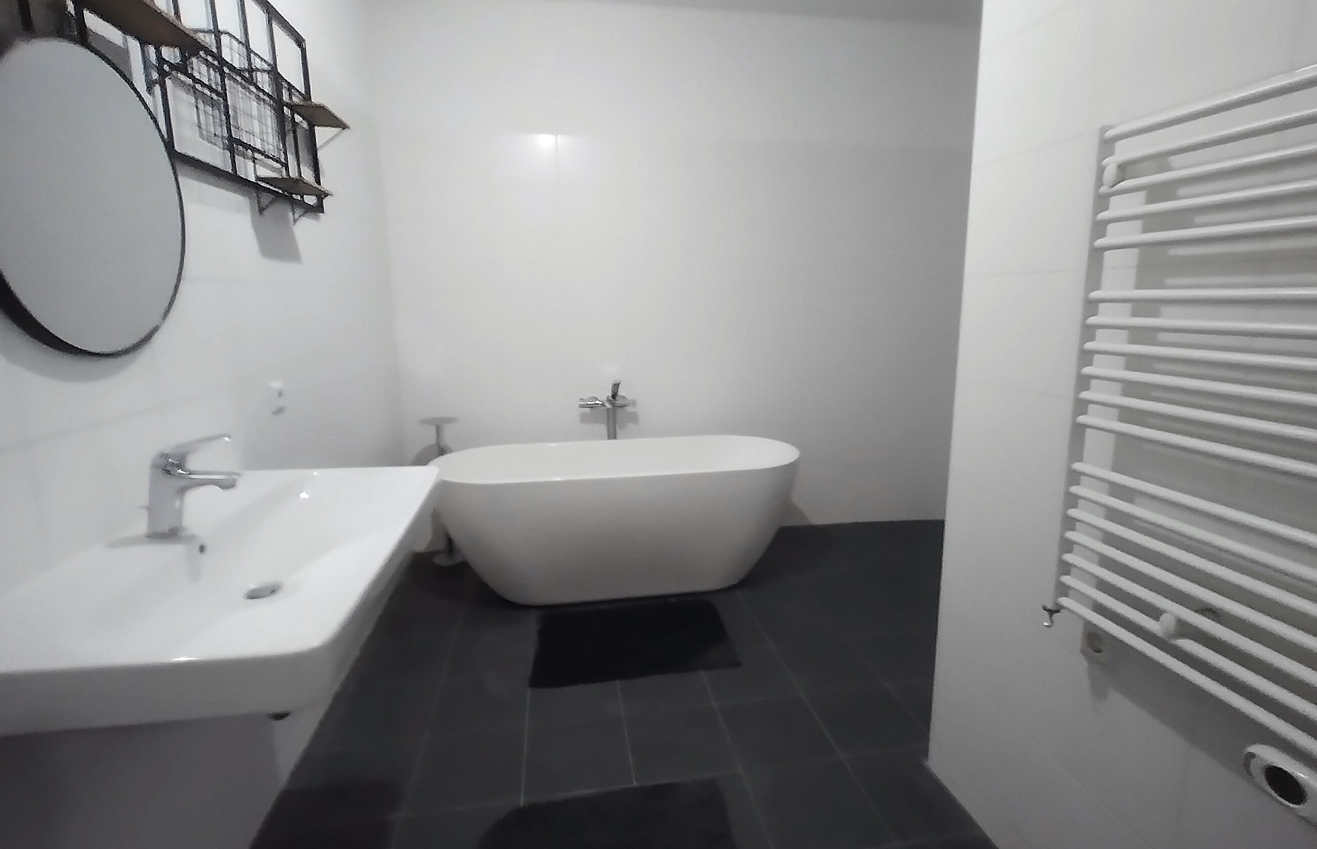 Badkamer met vrijstaand bad en regendouche met drainagegoot