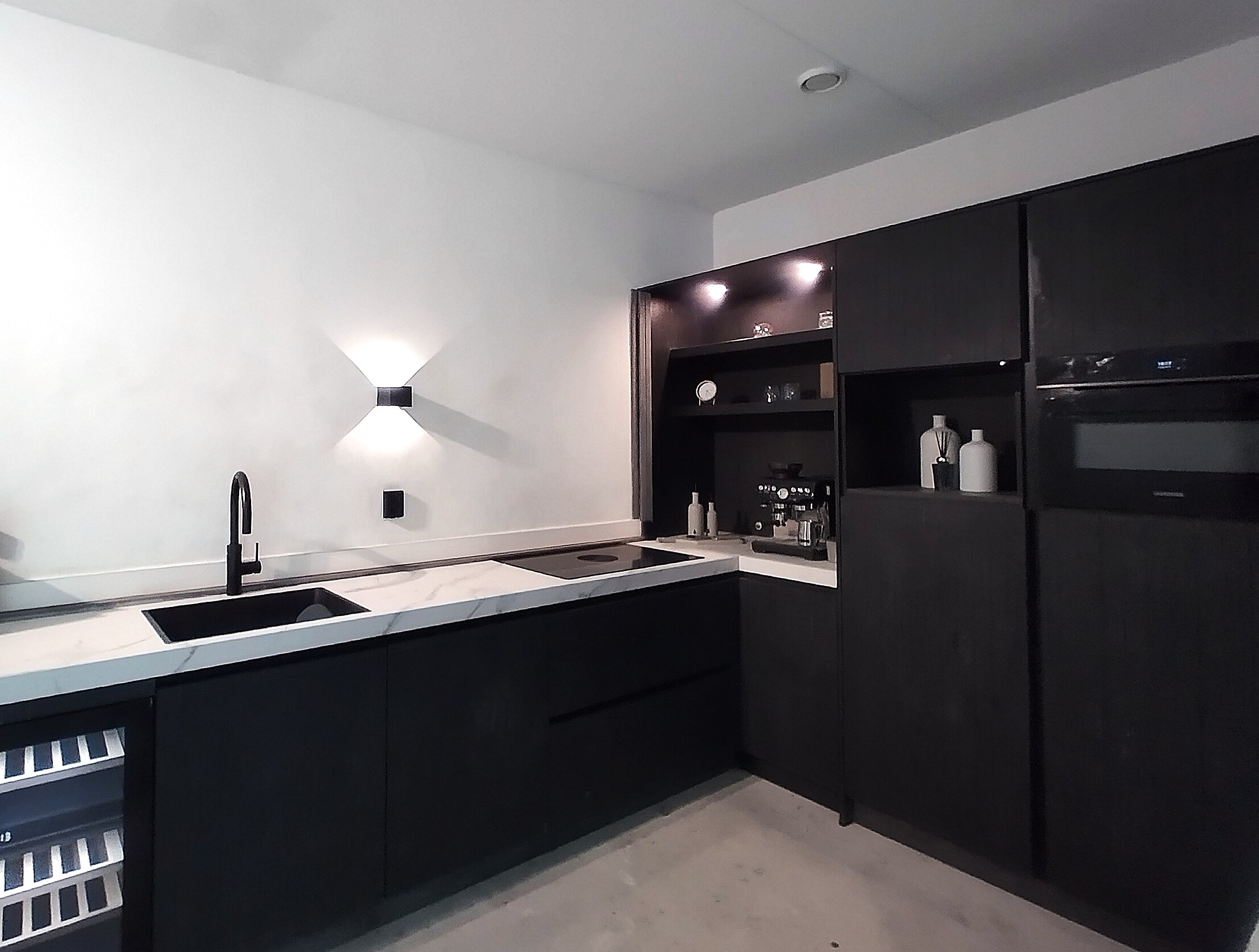 Keuken met mat zwarte eikenhouten kasten en wit Dekton-werkblad